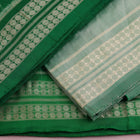 Close-up of the green Sambalpuri silk dress material blouse piece, detailed with traditional motifs.