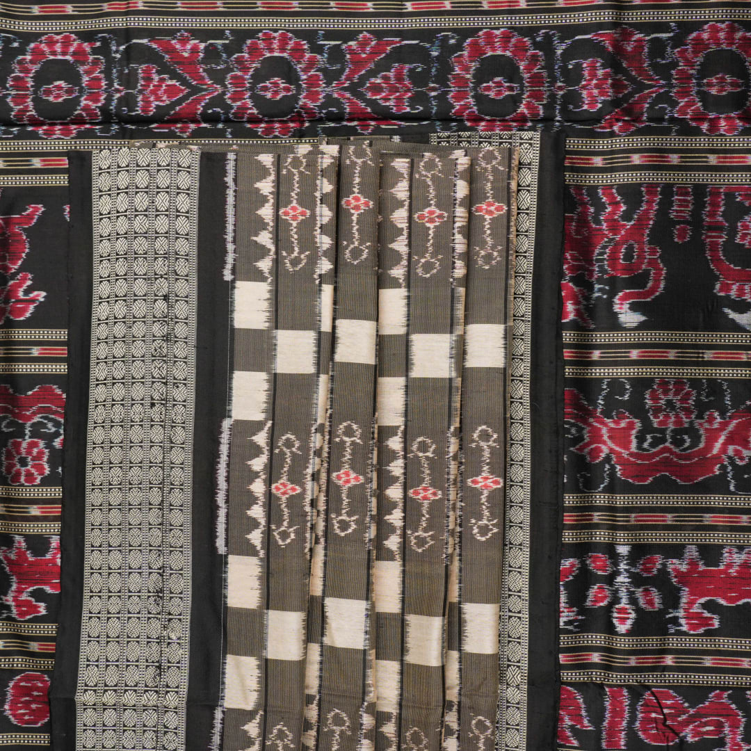 Close-up of the luxurious silk fabric texture and handloom weave of the grey and black Sambalpuri saree.