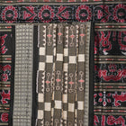 Close-up of the luxurious silk fabric texture and handloom weave of the grey and black Sambalpuri saree.