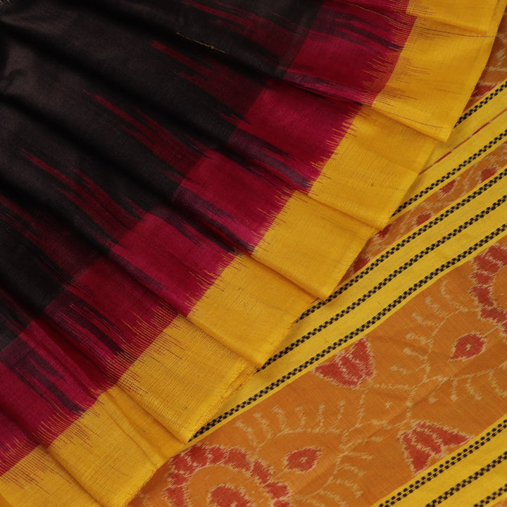 Close-up of black and gold Tussar silk saree fabric with intricate motif patterns