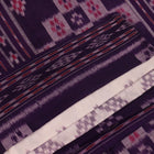 Elegantly draped red and violet Sambalpuri cotton saree with traditional motifs.