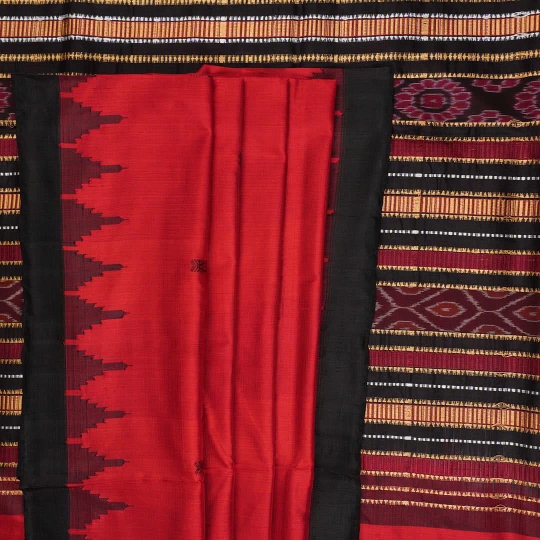 Detailed view of hand-woven silk fabric texture and butta patterns on a red Sambalpuri saree.
