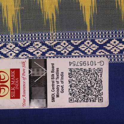 Textured close-up of yellow Bomkai silk saree fabric with blue butta pattern.