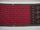 Model showcasing an elegant drape of a red and black Sambalpuri cotton handloom saree with traditional motifs