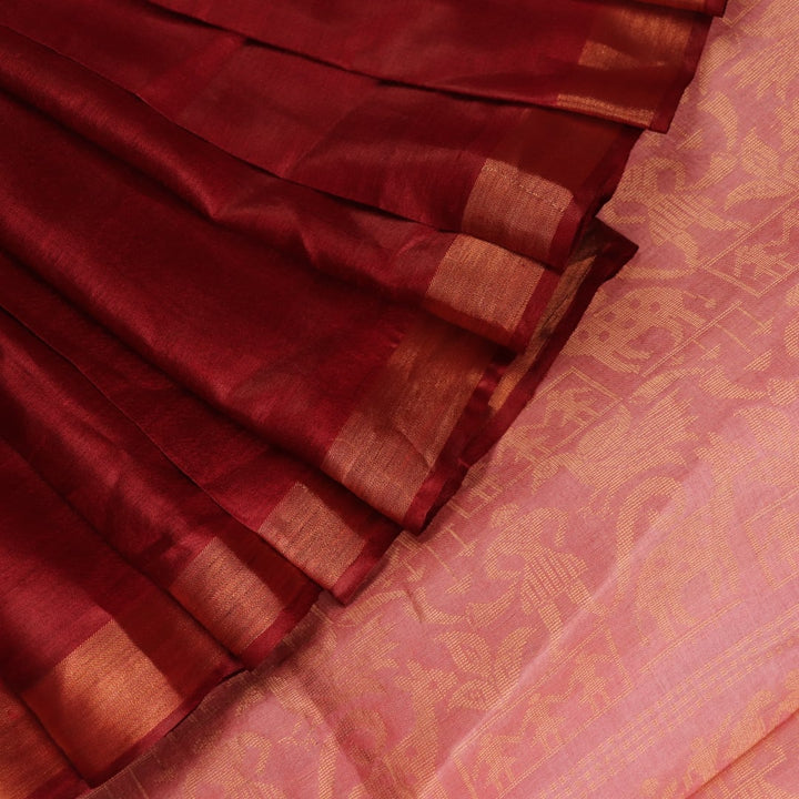 Close-up of intricate butta pattern woven on Tussar silk fabric in a maroon hue