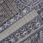 Close-up of the soft, luxurious grey Sambalpuri silk fabric texture with subtle weave details.