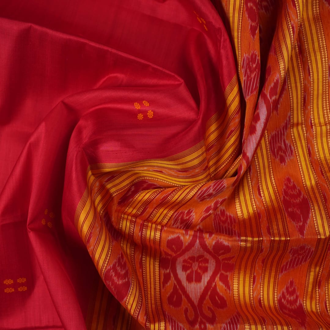 Model draped in a red and yellow Khandua silk saree with butta patterns for a traditional look.