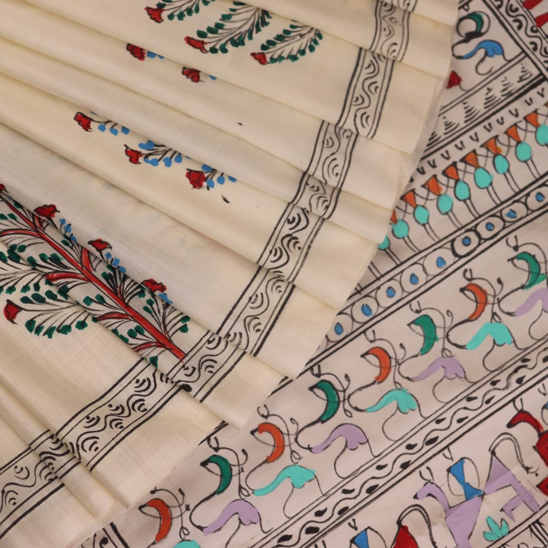 Close-up of the white silk saree fabric texture, showcasing the handloom weave and painted Patachitra details.