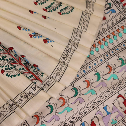 Close-up of the white silk saree fabric texture, showcasing the handloom weave and painted Patachitra details.