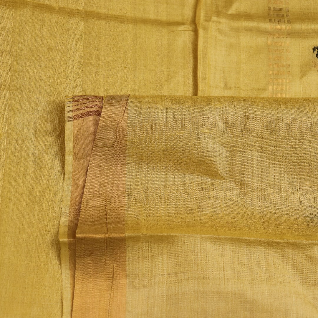 Close-up of yellow Tussar silk saree fabric with intricate butta patterns