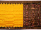 Model showcasing yellow Khandua silk saree with black butta pattern.