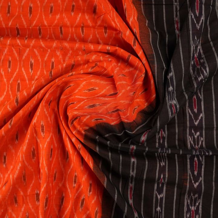 Model wearing an orange and black Sambalpuri cotton saree, styled in an elegant traditional drape.