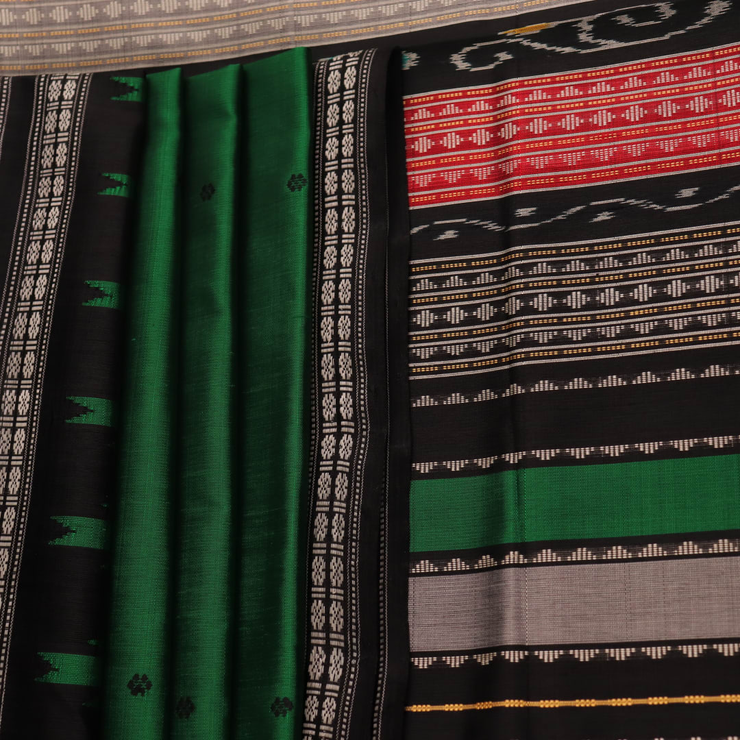 A close-up view of the lush, green silk fabric with a black butta pattern woven in.