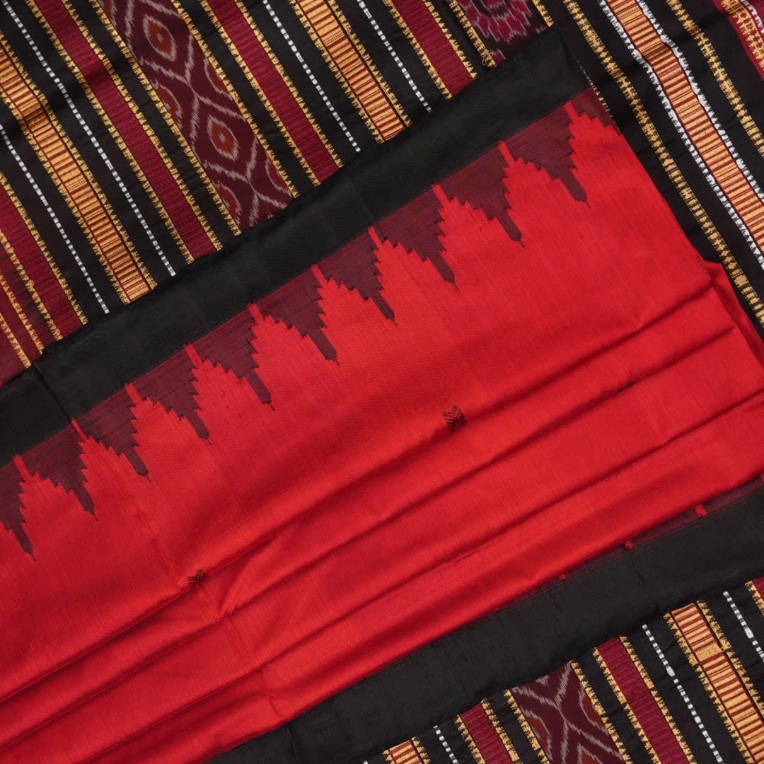 Detailed view of hand-woven silk fabric texture and butta patterns on a red Sambalpuri saree.
